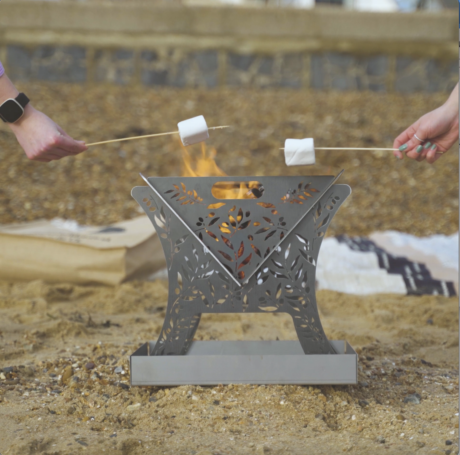 Compact fire pit on the beach with two marshmallows toasting Essex